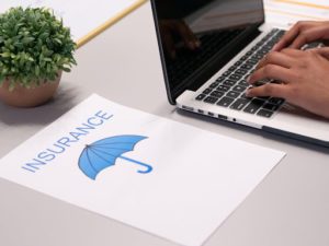Insurance page beside a laptop