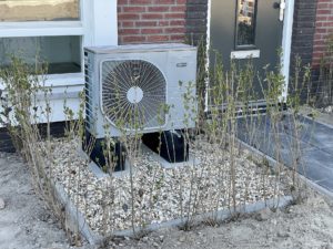 A heat pump installed outside a brick house